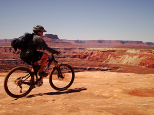 Dani Weigand rides on the edge of the White Rim Trail