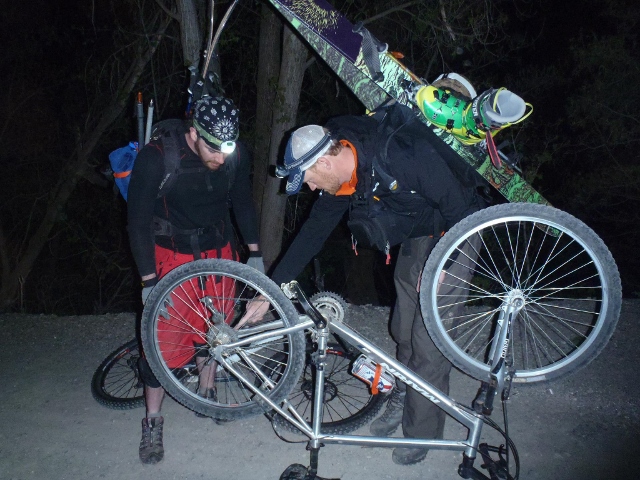 Nighttime trail-side bike repair with ski gear strapped to a pack over the Bergans of Norway Microlight Jacket (right.) Despite it all, the stretch,  4-way material meant the shall never hindered my movements. (Photo: Eric Ghanem)