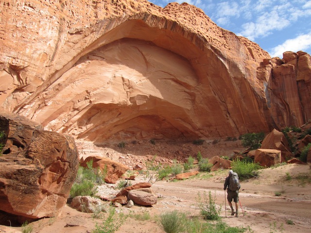 A hiker is dwarfed by an alcove in Wolverine Canyon. Wolverine contains a nice section of slots near the confluence with Horse Canyon. (photo: Ryan Malavolta/UtahOutside.com)