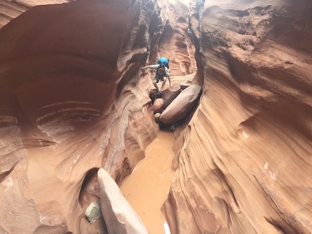 Little Death Hollow is usually a dry hike, but all slot canyons have the potential to contain water. The author makes his move over one of the many chockstones. (photo: Skip Whitman/Utahoutside.com)