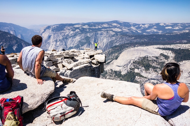 Hikers enjoy some relaxation on top of Half Dome while a bold soul poses on the Diving Board. (photo: Ryan Malavolta/Utahoutside)