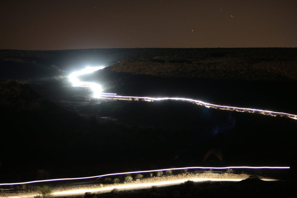 Lights illuminate the way as riders descend the Hurricane Rim Trail near Frog Town after dark. (Photo: Jared Hargrave - UtahOutside.com)